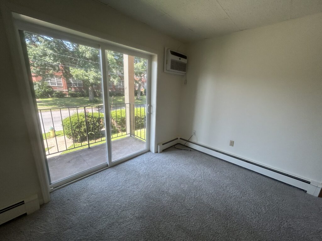 View of Living room with sliding glass doors at Sheridan St Apartments